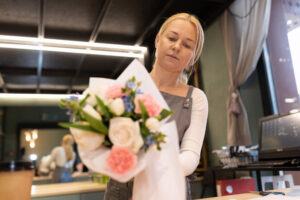 the manager of the flower salon collects a bouquet for a regular client